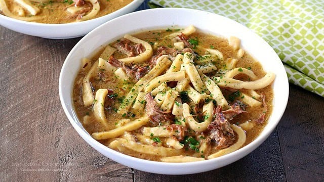 Slow cooker beef and noodles with tender shredded beef and thick egg noodles in savory beef broth
