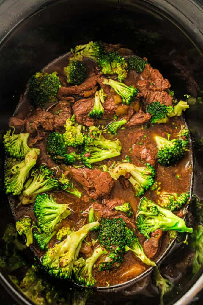 Cooked beef and broccoli in sauce inside a slow cooker