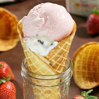 Homemade Waffle Cones in a jar with fresh strawberries.