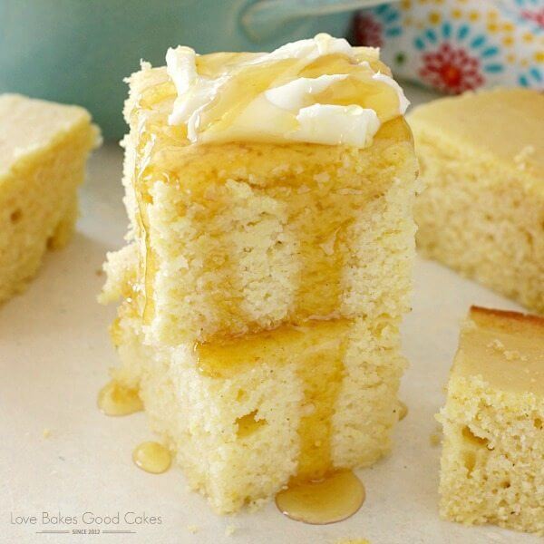 Southern Cornbread stacked up on a plate with butter and honey drizzle.