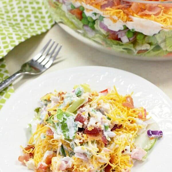 This 7 Layer Salad is the perfect addition to any meal or potluck. With layers of veggies, a tangy dressing, cheese, and bacon, this will be a new favorite!