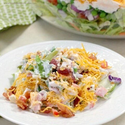 This 7 Layer Salad is the perfect addition to any meal or potluck. With layers of veggies, a tangy dressing, cheese, and bacon, this will be a new favorite!