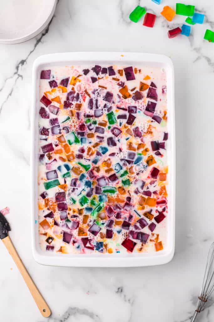 Broken Glass Jello dessert before chilling with colorful gelatin cubes in creamy milk mixture