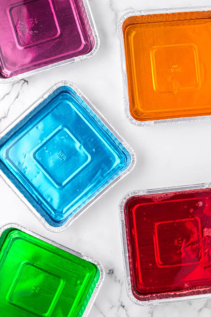 Colorful flavored gelatin setting in foil pans for Broken Glass Jello recipe