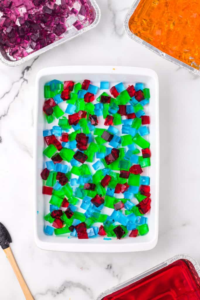 Colorful Jello cubes layered in baking dish for Broken Glass Jello dessert