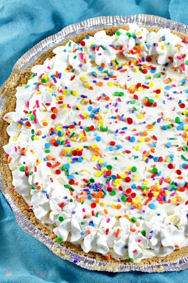 No-Bake Funfetti Cheesecake in a pie tin with rainbow sprinkles.