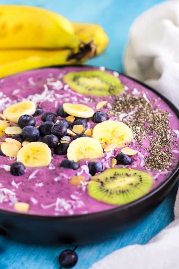 blueberry banana smoothie bowl garnished with fruit and chia seeds