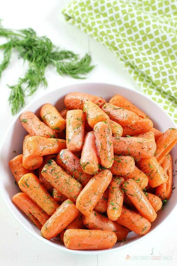 Dill Butter Carrots in a white bowl with fresh dill.