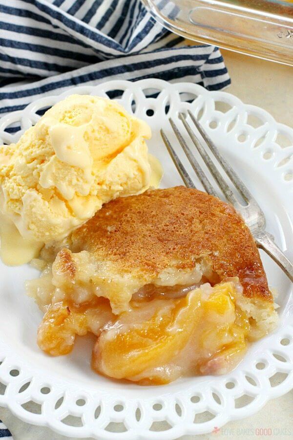 Easy Southern Peach Cobbler on a plate with ice cream and a fork close up.