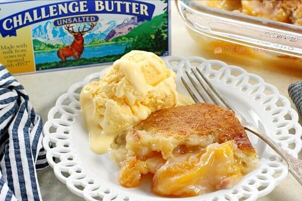 Easy Southern Peach Cobbler on a plate with ice cream and a fork.