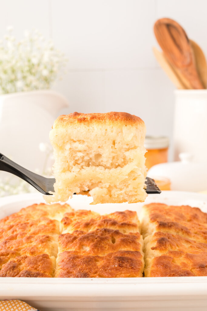 butter dip biscuit being lifted from the baking dish on a spatula