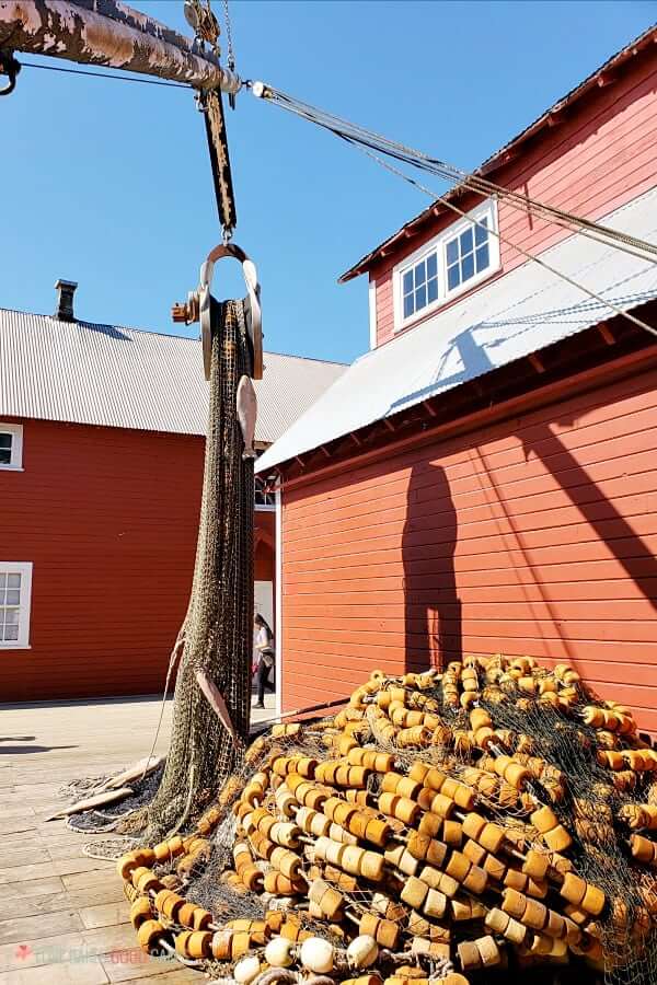 Alaska Fishing nets piled next to a red building.