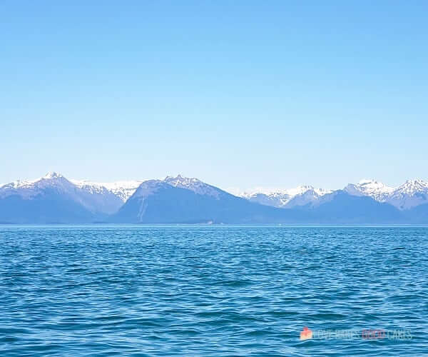 Top Ten Must-Dos on Embarkation Day - A body of water with snow covered mountains in the background.