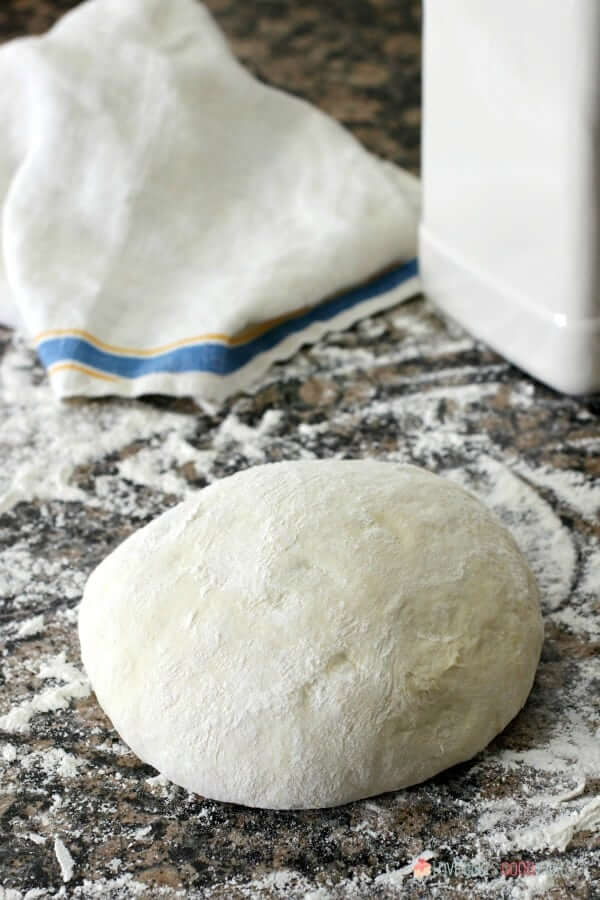 Cheesy Garlic Bread "Cinnamon" Roll dough on a counter top.