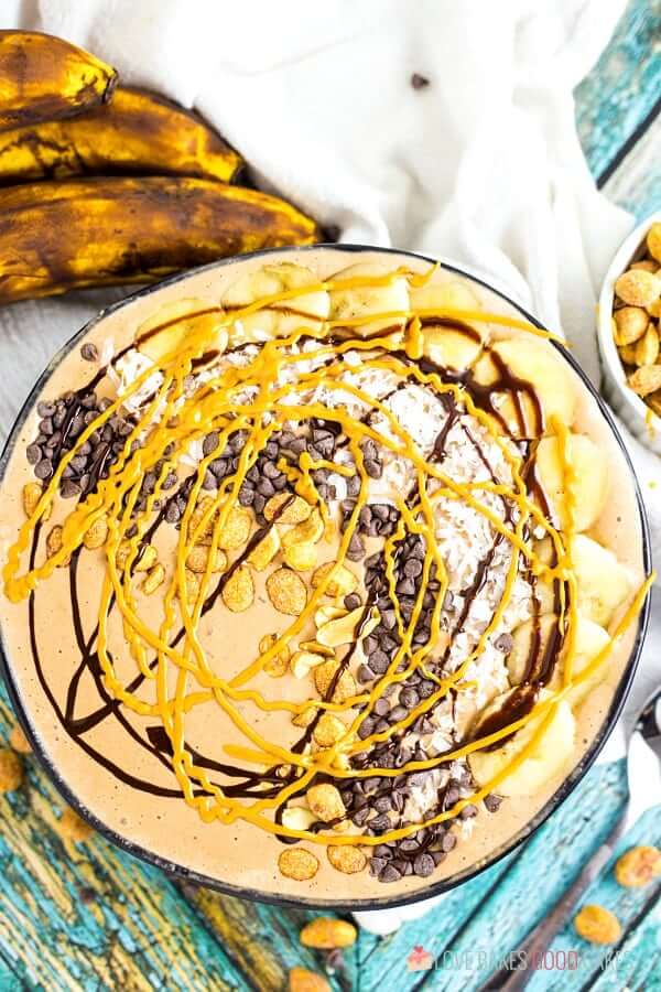 Chocolate Peanut Butter Smoothie in a bowl with fresh bananas and toppings.