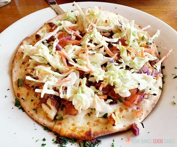 Fish taco pizza on a plate.