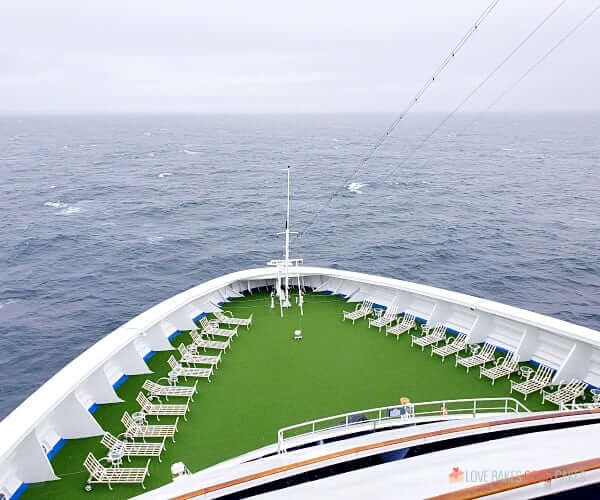 The bow deck on a cruise ship with lounger chairs.
