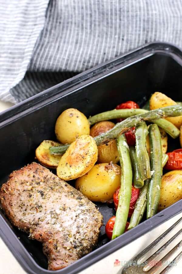Italian Pork Chop Sheet Pan Dinner in a storage container with a fork.