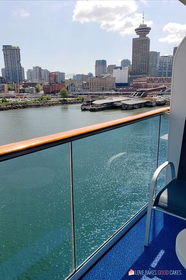 Looking down from the private patio deck on a cruise ship towards the skyline of a large city.