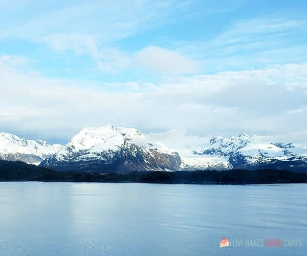 A body of water with snow covered mountains in the background.