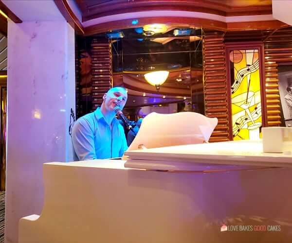 An entertainer plays piano in a bar on a cruise ship.