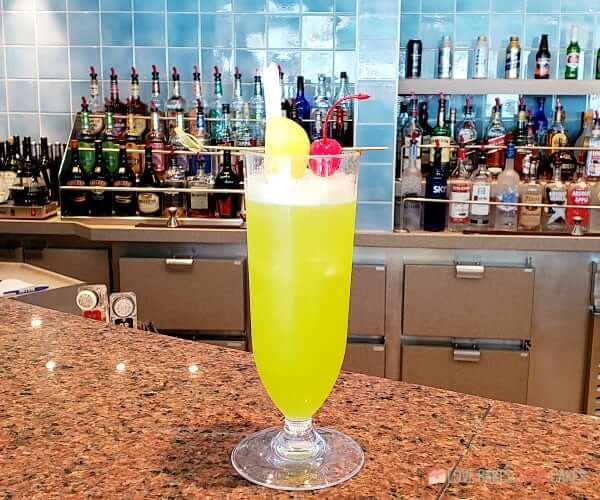 Top Ten Must-Dos on Embarkation Day- An alcoholic beverage sits on a bar top of a cruise ship.
