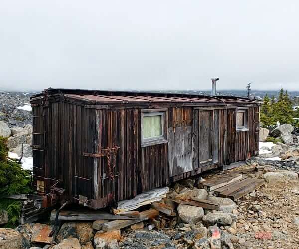 A wooden train car that has been converted to a living space.