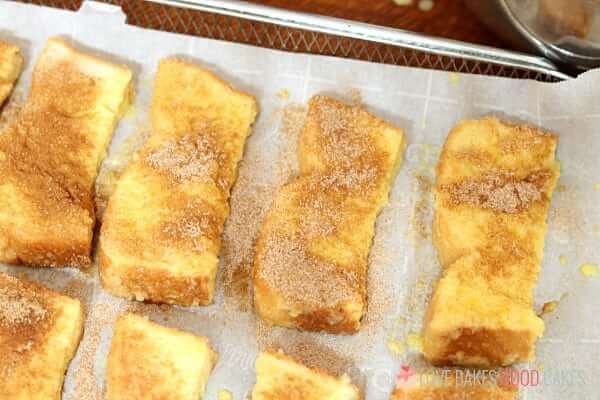 Air Fryer French Toast Sticks being prepared to be placed inside air fryer for cooking.