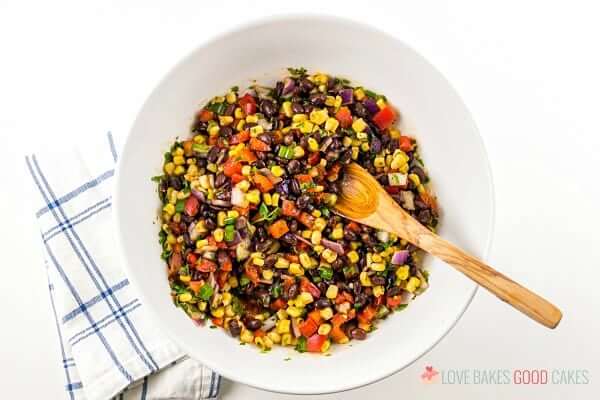 Black Bean and Corn Salsa in a white bowl with the dressing mixed in. 