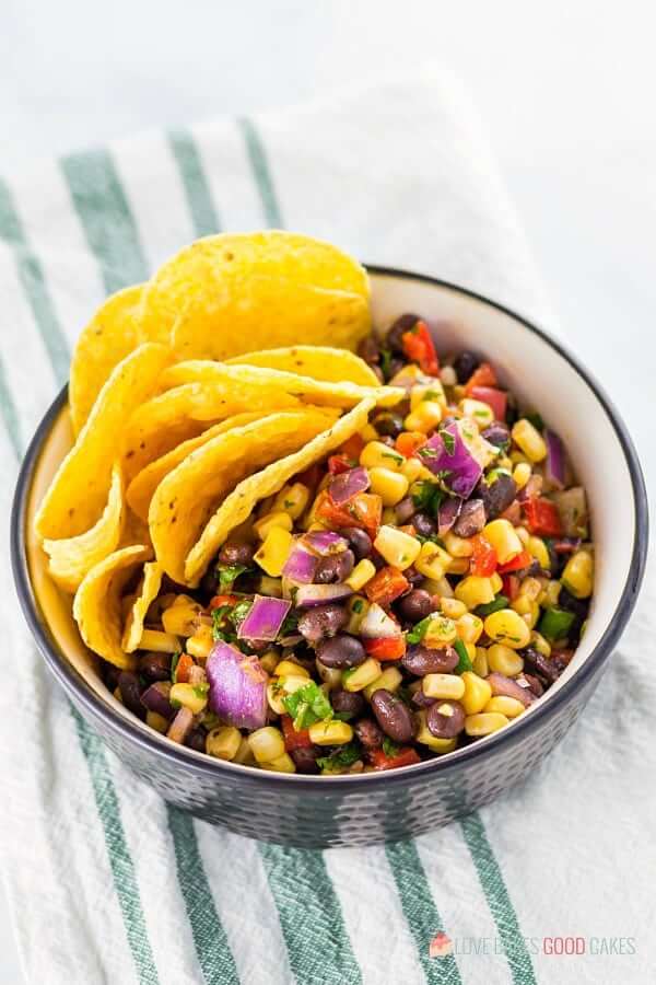 Black Bean and Corn Salsa in a black bowl with tortilla chips.