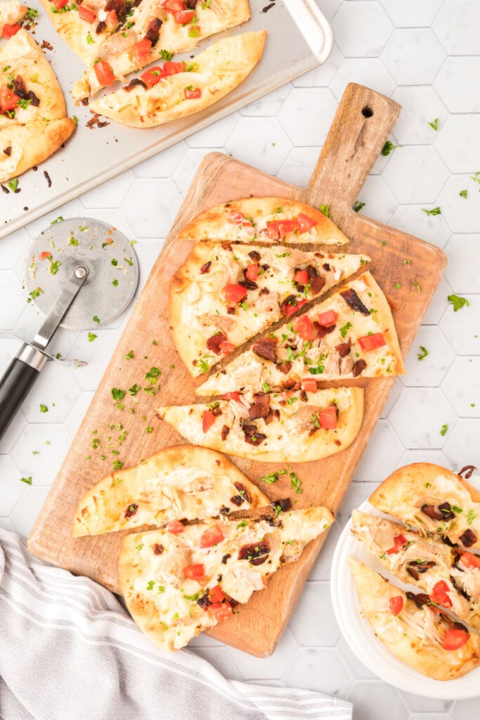 chicken bacon ranch naan bread pizza on wooden paddle cutting board