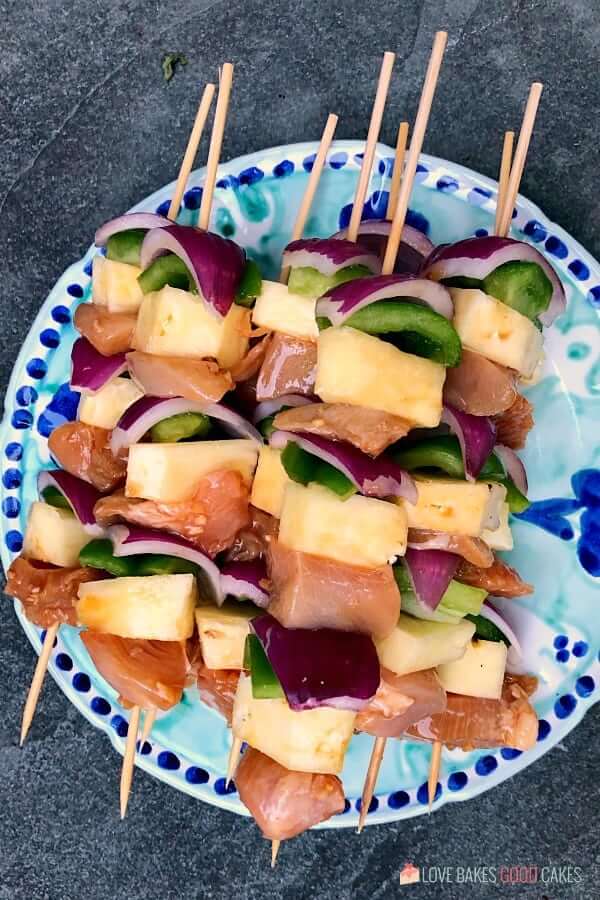 Hawaiian Chicken Kebabs assembled on a plate ready to be put into the oven.