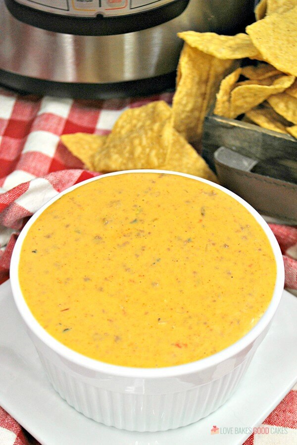 Instant Pot Mexican Queso in a white bowl with tortilla chips.