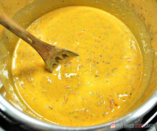 Instant Pot Mexican Queso being mixed up in a metal bowl.