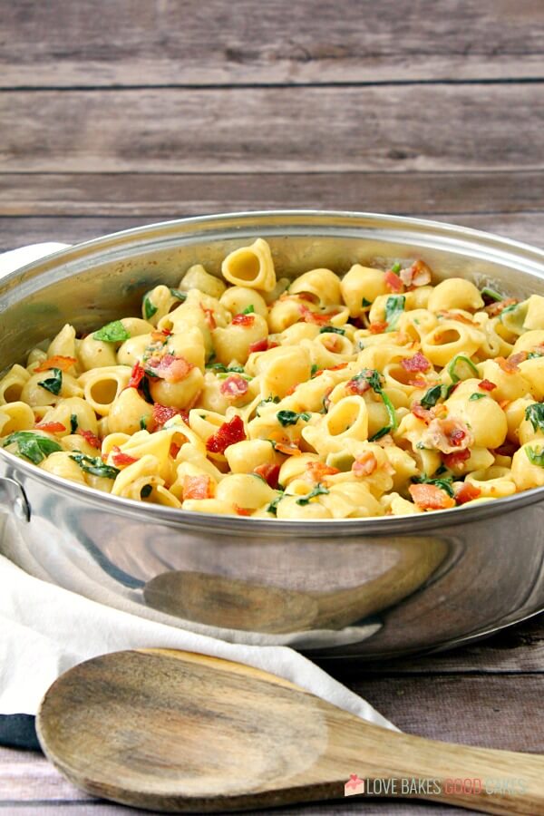 One Pot Creamy Bacon Spinach Pasta in a skillet with a spoon.