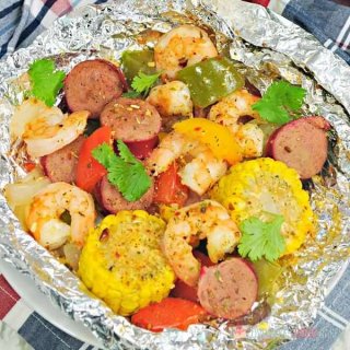 Spice up dinner with these Shrimp Boil Foil Packets! Bake or grill this easy mix of corn, sausage, shrimp, onions, and bell peppers with a zesty Cajun seasoning mix.