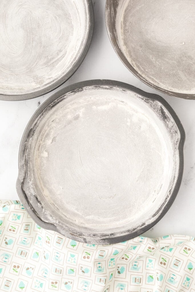 Three 9-inch cake pans greased and floured for baking Chocolate Milk Cake