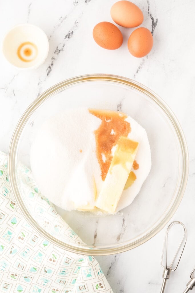Butter, sugar, vanilla, and eggs in a mixing bowl for Chocolate Milk Cake batter