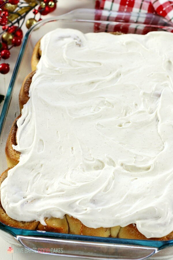 Eggnog Cinnamon Rolls in a baking dish with white creme frosting.