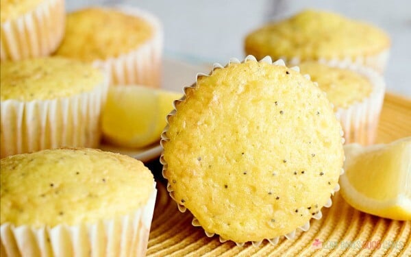 Lemon Poppy Seed Muffins piled up on a serving plate.