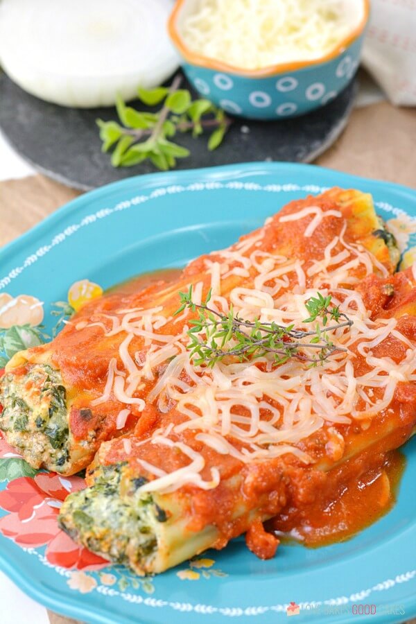 two Spinach Ricotta Manicotti on a blue plate