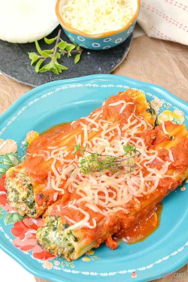 Spinach Ricotta Manicotti on a blue plate.