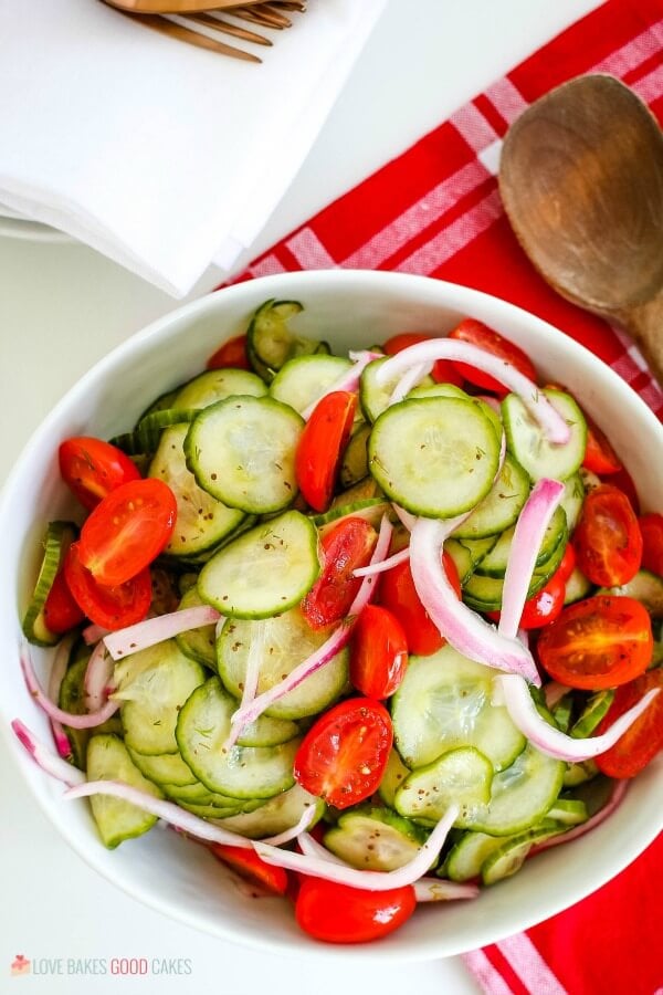 Zesty Cucumber Tomato Salad in a white bowl with red towel