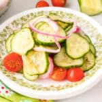 Close-up square image of cucumber tomato salad on a plate with onions and tomatoes