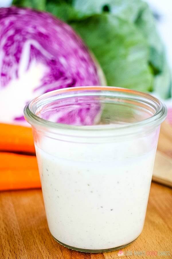 Coleslaw Dressing in a glass cup with fresh vegetables close up