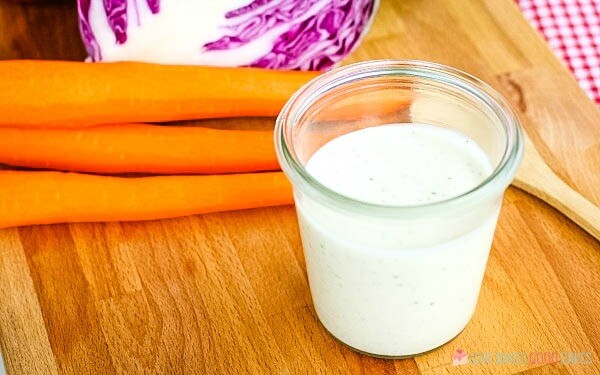 This Coleslaw Dressing has the perfect balance between tangy and sweet. Pour it over pre-shredded cabbage or use your own mix of cabbage and carrots for the perfect side dish any time! finished product on a wooden board
