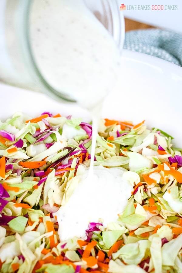 This Coleslaw Dressing has the perfect balance between tangy and sweet. Pour it over pre-shredded cabbage or use your own mix of cabbage and carrots for the perfect side dish any time! Making coleslaw by pouring dressing over it.