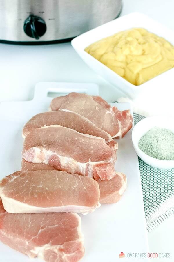 raw pork chops on plate with ingredients.
