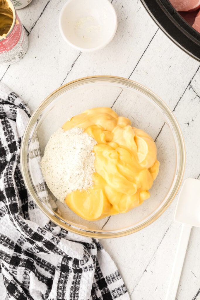 Mixing bowl filled with cream of chicken soup and dry Ranch seasoning before stirring.