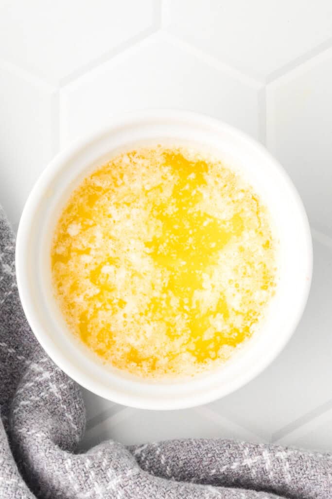 Melted butter in a white bowl, ready for the dipping sauce.